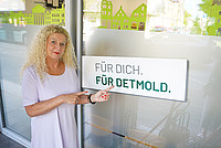 Teamleiterin Britta Contursi vor der Außenbeklebung der Türen an der Bürgerberatung Detmold