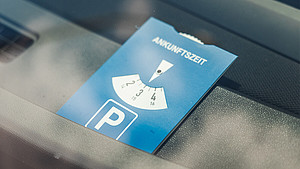 Nahaufnahme einer Parkscheibe hinter der Frontscheibe eines Autos