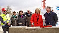Ein gezielter Hammerschlag der Parlamentarischen Staatssekretärin Sabine Poschmann aus dem Bundesministerium für Wohnen, Stadtentwicklung und Bauwesen schließt den Grundstein für die neuen Häuser am Adenauerpark. Rechts schaut Michael Hoppenberg (stv. Aufsichtsratsvorsitzender Wohnungsgenossenschaft Breitefeld) zu. Von links betrachten Stefan Lenz (Unternehmen Schulz), Aufsichtsrätin Corinna Peter-Werner, Dr. Miriam Mikus (Erste Beigeordnete und Kämmerin der Stadt Detmold), Thomas Lammering (Technischer Beigeordneter der Stadt Detmold) das Geschehen. 