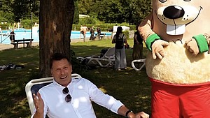 Bürgermeister Frank Hilker direkt neben dem Maskottchen "Hermi" im Freibad
