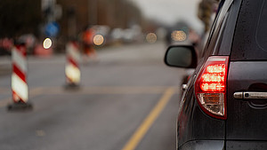 Nahaufnahme eines Autos von hinten mit unscharfen Absperrungen am Rand