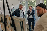 Staatssekretär Lorenz Bahr, Bürgermeister Frank Hilker und Martin Trittin (künstlerischer Leiter von Workshops für Jugendliche) (von rechts) schauen sich gemeinsam ein Kunstwerk an