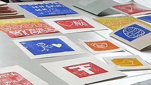 Ein weißer Tisch auf dem mehrere Kunstwerke eines Linoldruck-Workshops zu sehen sind