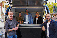 Außenaufnahme mit (von links) Marktmeister Jens Berghahn, Ann-Christin Lüersen (Gilde Wirtschaftsförderung), Bürgermeister Frank Hilker, Sabine Rosner (Zukunftsmanagerin Innenstadt) sowie Andreas Busch (stellvertretender Marktmeister) vor und in dem neuen Verkaufsanhänger