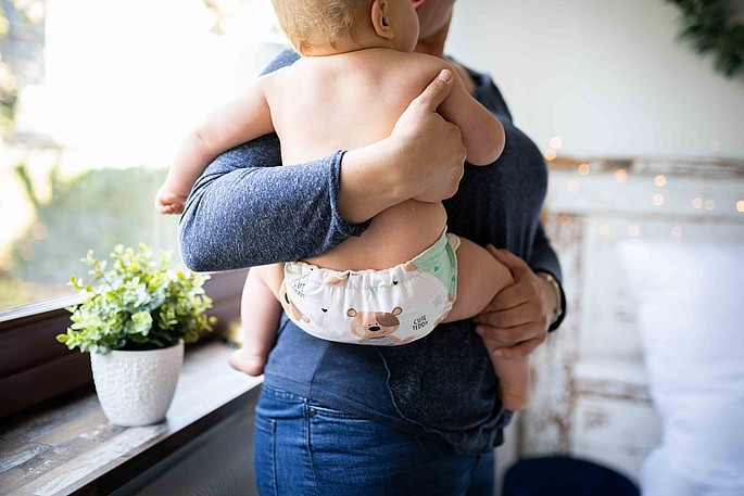 Ein Baby mit einer Stoffwindel auf dem Arm einer Frau