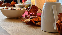 Aufnahme eines herbstlich dekorierten Tisches mit Kerzen, getrockneten Blättern und Knabbereien im PUB.I.T der Stadt Detmold