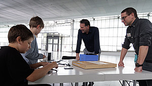 Bürgermeister Frank Hilker an einem Tisch mit mehreren Kinder während der LEGO-Bauaktion im Hangar 21