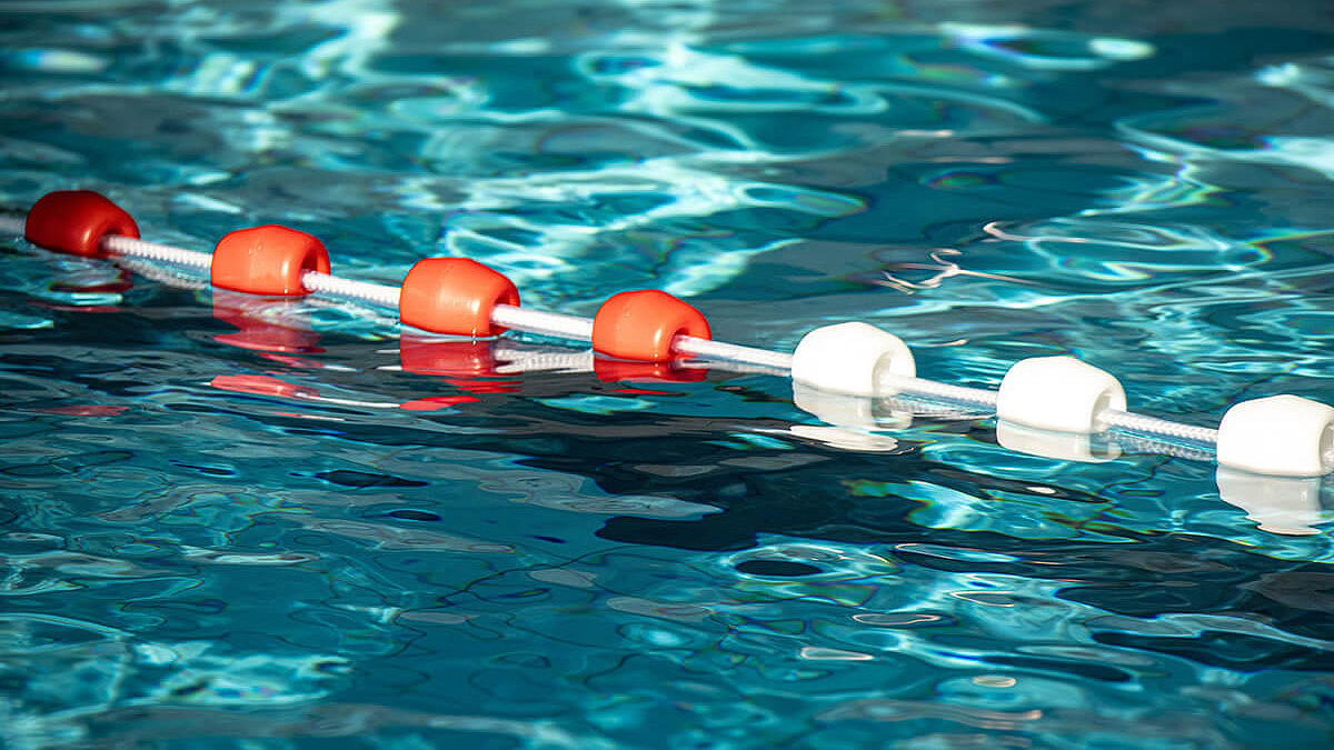 Bunte Poolbojen auf der Wasseroberfläche eines Freibadbeckens