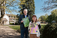Der Vorsitzende des Heimatvereins Hiddesen, Cord Brüning (links) und Kathrin Prill, Koordinatorin für das Ehrenamt bei der Stadt Detmold, halten die Werbeplakate für das Ortsteilfest in Hiddesen in den Handen.