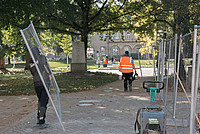 Mehrere Personen räumen Bauzäune auf dem Schlossplatz weg