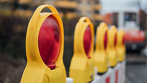 Nahaufnahme der Lampen an einem Absperrzaun