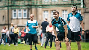 Mehrere Fußballspieler stehen auf der Wiese vor dem Fürstlichen Residenzschloss in Detmold. Im Hintergrund sind mehrere Zuschauer zu sehen.
