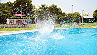 Kind springt in ein Freibadbecken und verursacht dabei mehrere Wasserspritzer