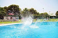 Kind springt in ein Freibadbecken und verursacht dabei mehrere Wasserspritzer