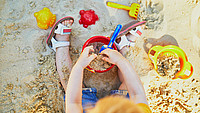Kind spielt in einem Sandkasten
