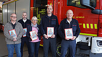 Ingo Brinkmann (Förderverein Feuerwehr Detmold), Andreas Weniger (Gefahrenabwehr Feuerwehr Detmold), Sabine Gerhardts (Vertriebsleitung K&L Verlag), Carsten Solle (Stadtfachwart für Brandschutzerziehung) und Joachim Wolf (Leiter der Feuerwehr Detmold) präsentieren die neuen Malbücher zur Brandschutzerziehung