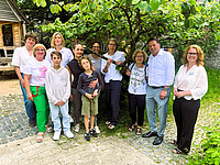Gruppenaufnahme in der Natur vor einem Baum. Darauf zu sehen sind (von links) Joanna Stöcker, Ulrike Räker und Esther Rosenbrock (Fachbereich Jugend, Schule und Sport), Dr. med. Jessica Gawenda (Gynäkologin) und ihre Söhne Konstantin und Theo, Familienlotsin Friederike Müller, Dr. Natalie Hellermann (Kinderärztin), Monika Dreise (Mutter von Dr med. Gawenda), Bürgermeister Frank Hilker und Jennifer Sonneborn (Leiterin des Fachbereichs für Jugend, Schule und Sport).