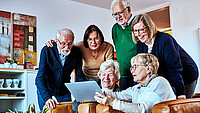 Senioren schauen zusammen auf ein iPad