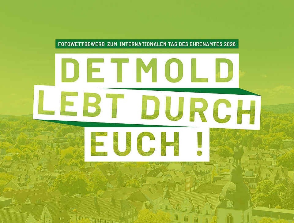 Luftaufnahme über Detmold mit einem hellgrünen Overlay und den Worten "Detmold lebt durch euch!" und "Fotowettbewerb zum internationalen Tag des Ehrenamtes 2026" darauf