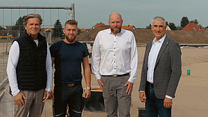 Roland Draier, Geschäftsführer des Unternehmens topocare, Kristian Greger vom Tiefbauunternehmen Dreger, Andreas Hoffmann (Tiefbauplanung der Stadt Detmold) und Thorsten Paulussen, Beigeordneter der Stadt, stehen vor dem neuen Lärmschutzwall am im Bau befindlichen Gewerbegebiet „Alte Ziegelei“