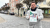Außenaufnahme von Bürgermeister Frank Hilker in der Detmolder Innenstadt mit der DEKRA Vision Zero Urkunde in den Händen