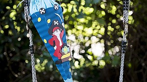 Eine gebastelte Schultüte lehnt an dem Seil einer Outdoor-Schaukel