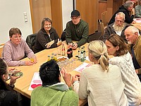 Teilnehmende der Heimatkonferenz diskutieren gemeinsam an einem Tisch