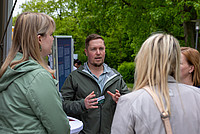 Tom Lachmann, Teamleitung des Stadtkontakts der Stadt Detmold, spricht vor drei Frauen in der Natur