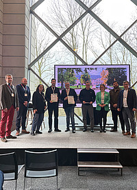Freuen sich über die Auszeichnung: (von links) Guido Bauer (Büro Bauer-Fecke, Bauleitung Schloßplatz), Andreas Hoffmann, Stadt Detmold - Fachbereich Tiefbau, Teamleitung Gewässer und Hochwasserschutz, Susanne Hoffjann, Stadt Detmold - Projektleitung Schloßplatz Detmold, Fachbereich Stadtentwicklung, Teamleitung Umweltschutz/Freiraumplanung, Lasse Malzahn, Planungsbüro Franz Reschke Landschaftsarchitektur Berlin, und Thomas Lammering, Technischer Beigeordneter der Stadt Detmold. Daneben die Donatoren: Peter Köddermann, Baukultur Nordrhein-Westfalen, Laura Knappmann, Knappmann Unternehmensgruppe, Marcel Wiegard, Bund Deutscher Landschaftsarchitekten NRW und Andreas Giga, Emschergenossenschaft und Lippeverband.