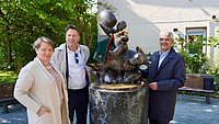 Schaepin Karolien Mondelaers, Bürgermeister Frank Hilker und sein Hasselter Amtskollege Steven Vandeput präsentieren das Borrelmanneke mit seinem Mäntelchen auf dem Hasselter Platz in Detmold.