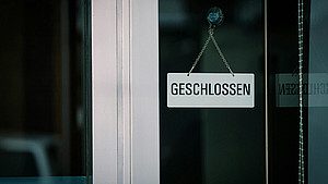 Schild mit dem Wort "Geschlossen" an einer Glastür