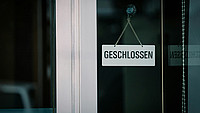 Schild mit dem Wort "Geschlossen" an einer Glastür