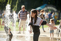 Kinder spielen mit dem Wasserspiel am Kaiser-Wilhelm-Platz