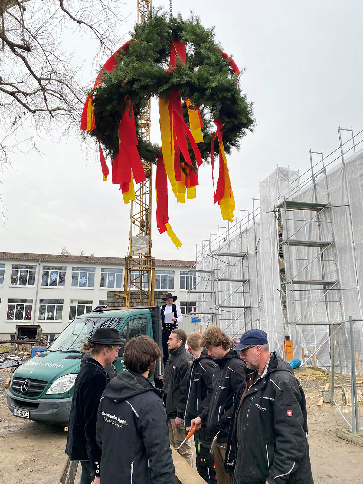 Die Zimmerleute klopfen Hillebille, während Meister Christian Schmidt den Richtspruch hält.