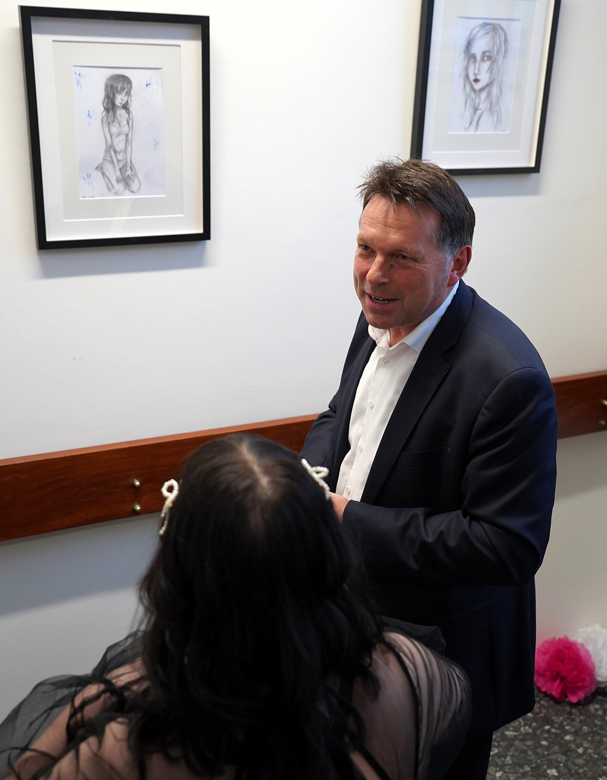 Bürgermeister Frank Hilker während der Ausstellungseröffnung von Philin T. vor den Zeichnungen
