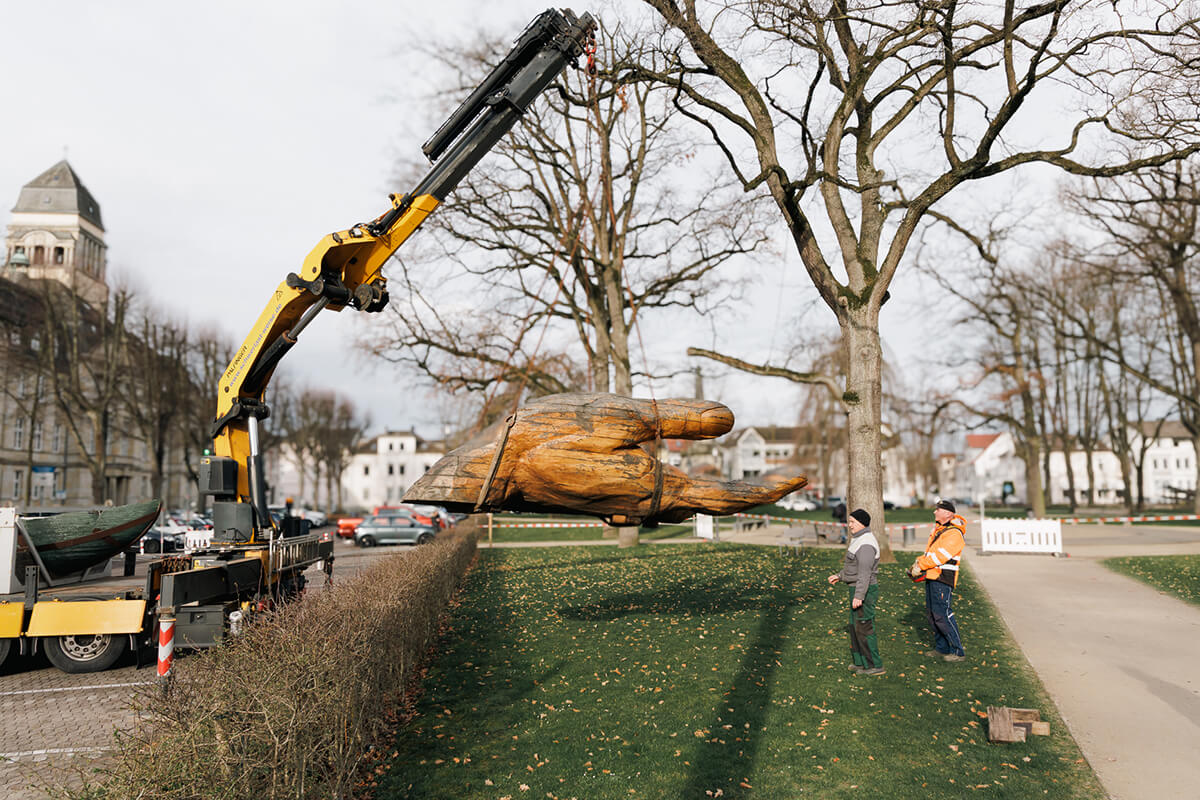 Rainer Helms vom Landschaftspflegeverein „Mittleres Elstertal“ und Transportunternehmer Frank Thomas bringen die „Glasarche 3“ auf dem Detmolder Kaiser-Wilhelm-Platz in Position.
