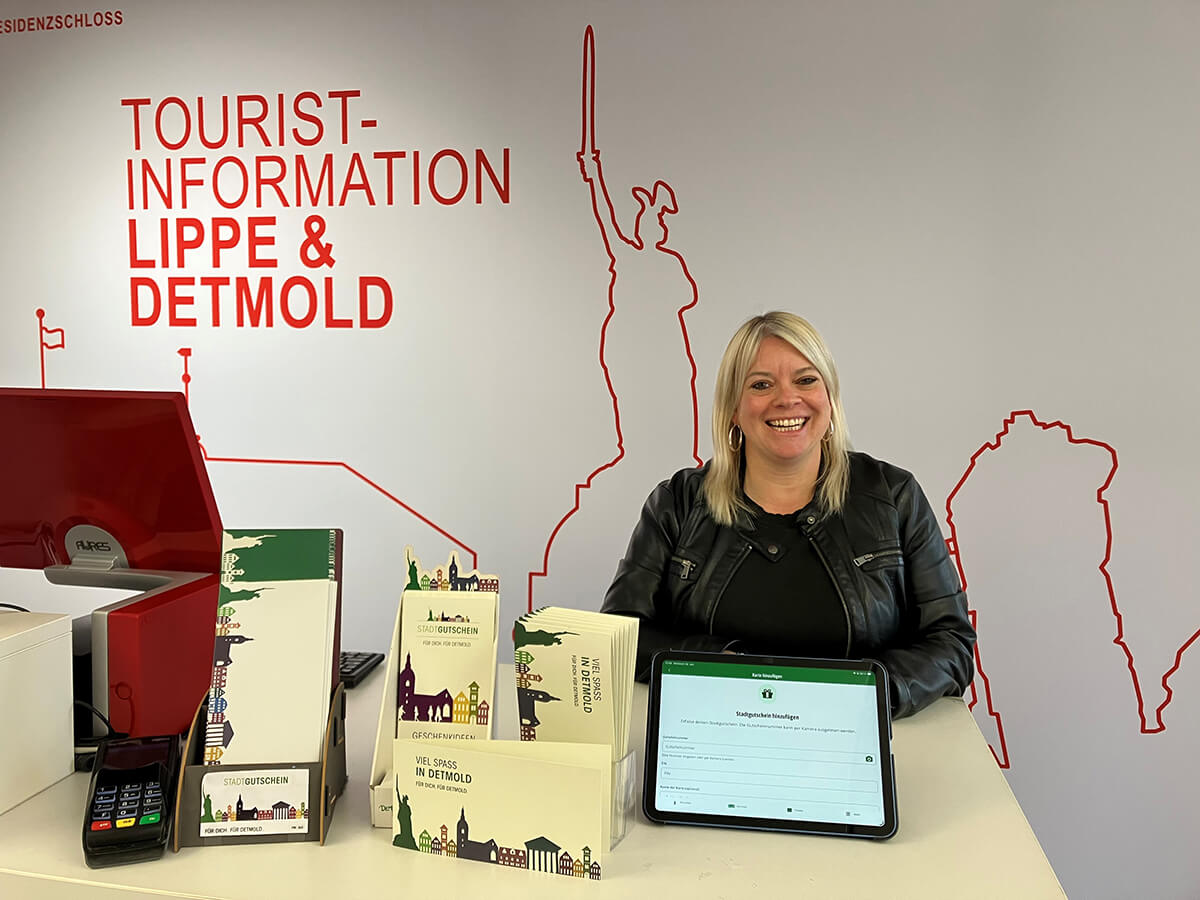 Vanessa Rubart, Teamleiterin der Tourist Information Lippe und Detmold, zeigt den digitalen Stadtgutschein im neuen Wallet-Modul in der Stadtapp „Appmold“