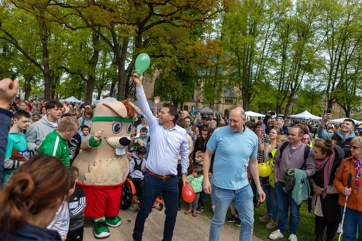 Bürgermeister Frank Hilker und Hermi, das Mas-kottchen, feiern gemeinsam mit den Teilnehmenden den Hermi-Lauf
