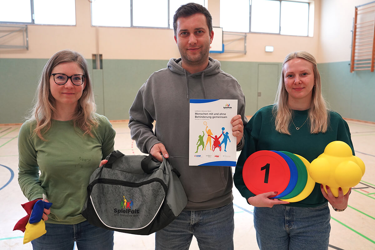 Merle Malburg (Stadt Detmold), Christopher Tegethoff und Julia Düchting (beide KSB Lippe) präsentieren die inklusive Sporttasche.