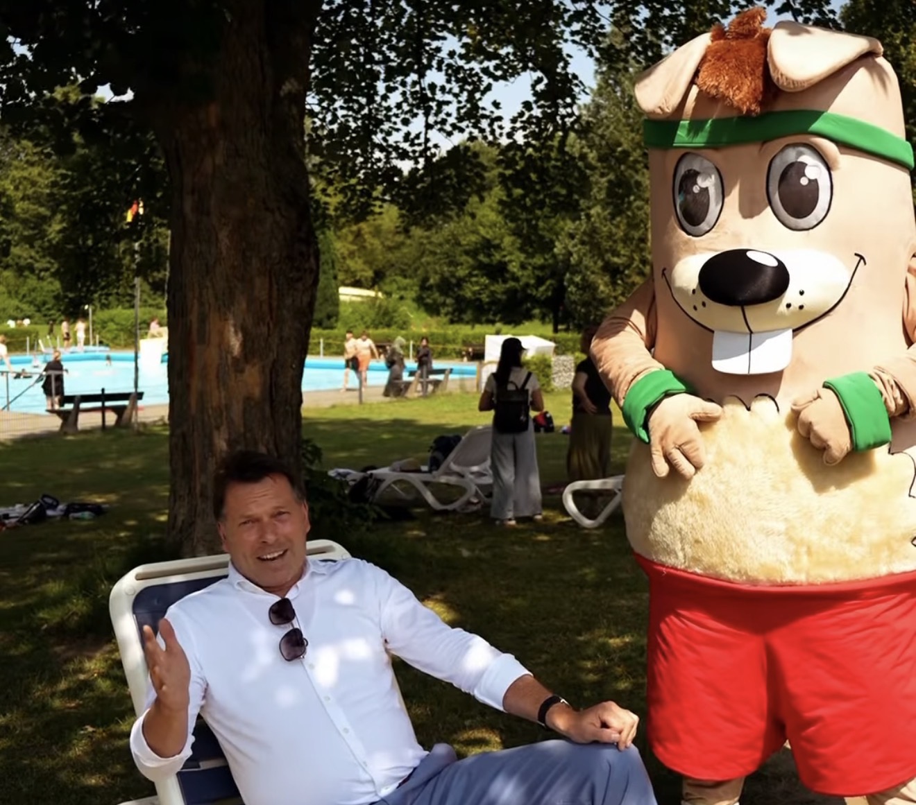 Bürgermeister Frank Hilker direkt neben dem Maskottchen "Hermi" im Freibad
