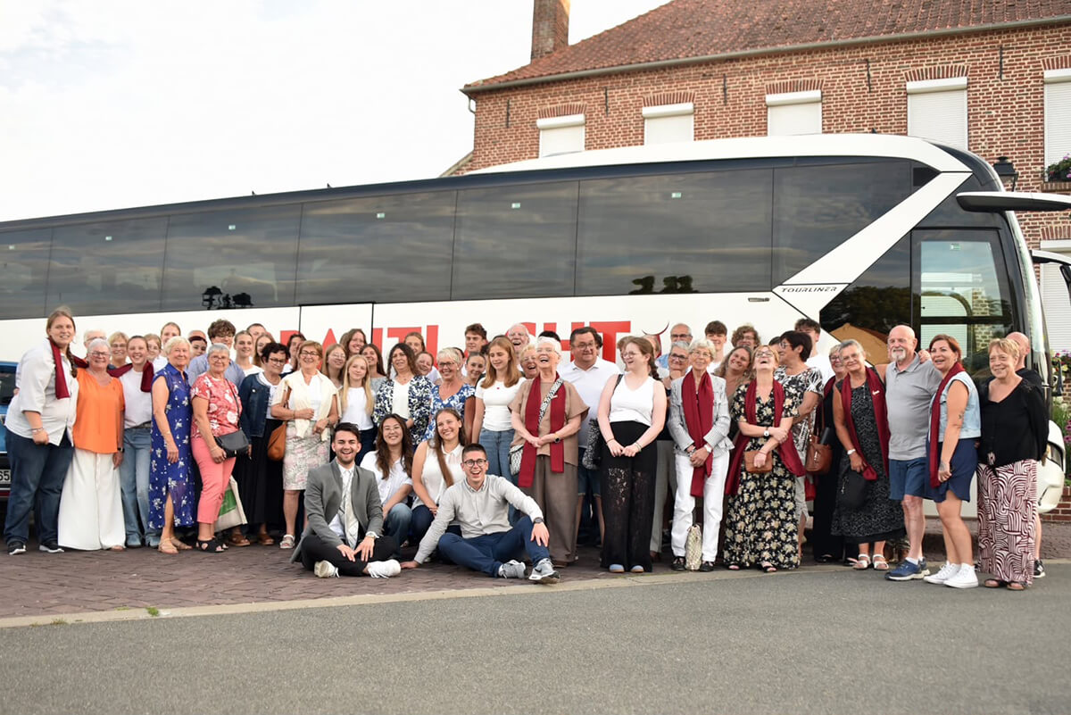 Gruppenbild der Mitglieder der detmolder Jugendchöre Voice Kamp und Martin-Luther-Youth-Choir MYC vor einem Bus