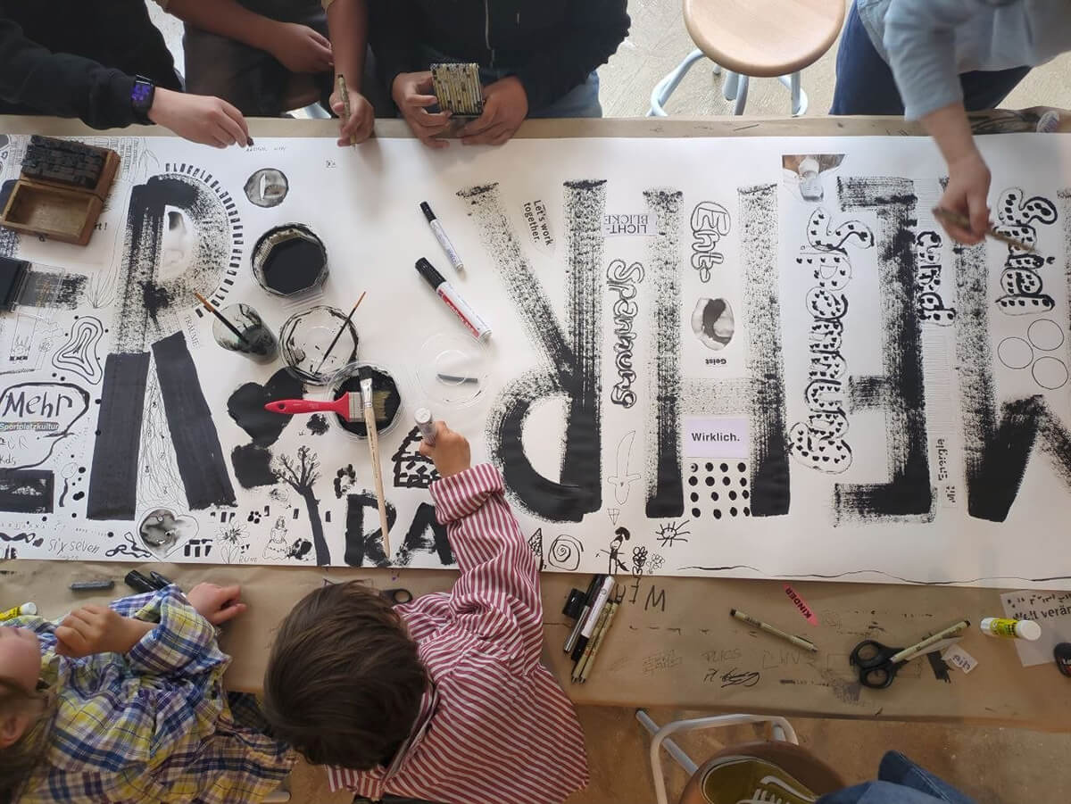 Personen malen auf einem Kunstwerk während der Detmolder Design Woche im PUB.I.T.