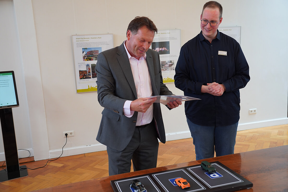 Bürgermeister Frank Hilker und Teilprojektleiter Pierre Rotthoff zeigen die Möglichkeit die multifunktionale Nutzung von Parkflächen