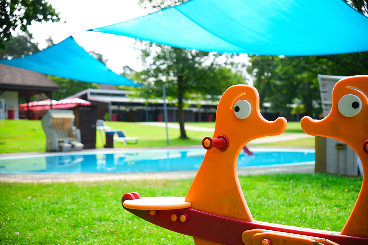 Nahaufnahme einer orangenen Kinderwippe auf einem Freibadgelände in Detmold