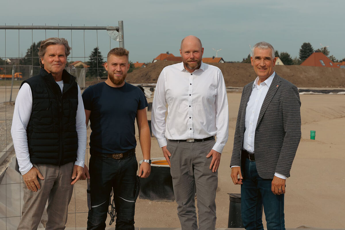 Roland Draier, Geschäftsführer des Unternehmens topocare, Kristian Greger vom Tiefbauunternehmen Dreger, Andreas Hoffmann (Tiefbauplanung der Stadt Detmold) und Thorsten Paulussen, Beigeordneter der Stadt, stehen vor dem neuen Lärmschutzwall am im Bau befindlichen Gewerbegebiet „Alte Ziegelei“